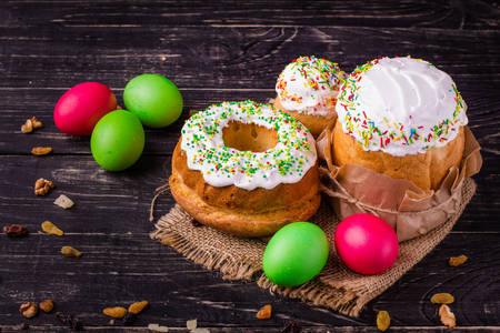 Velikonoční dorty a velikonoční vajíčka na dřevěný stůl