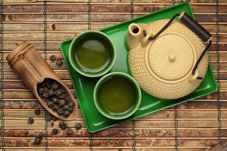 Bule e xícaras com chá verde