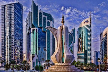 Escultura con el telón de fondo de los rascacielos en Doha
