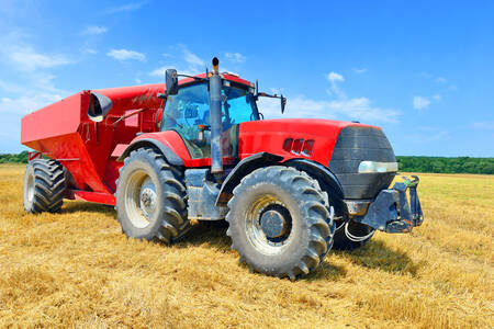 Czerwony traktor z przyczepą