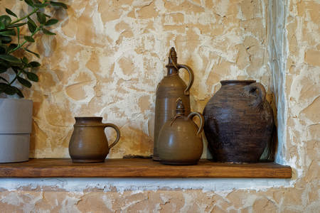 Clay jugs on a wooden shelf
