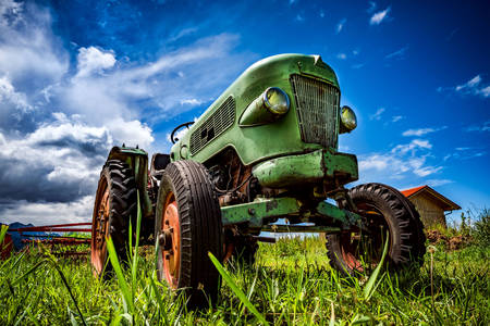 Gammal traktor på en gård