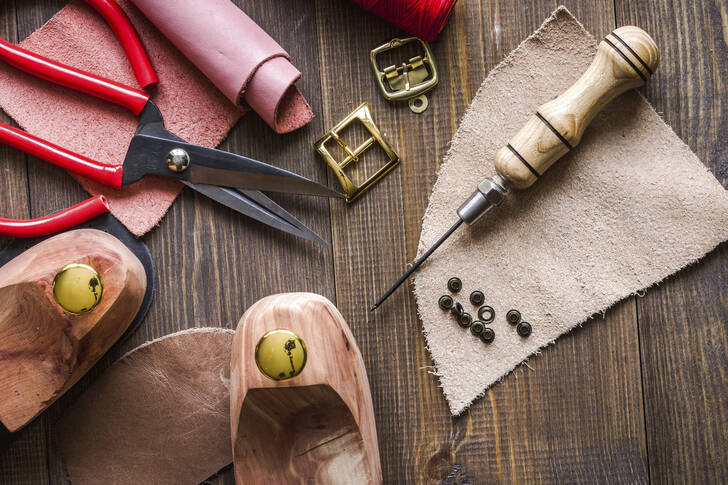 Cobbler's tools on a wooden background