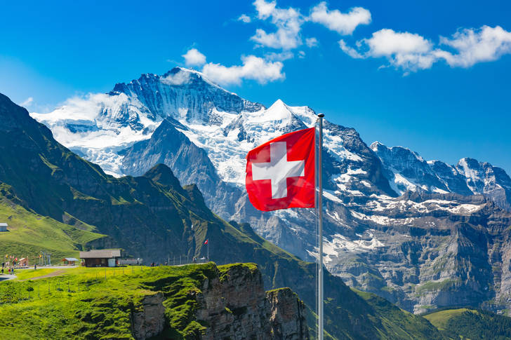 Swiss flag on the background of the Jungfrau mountain