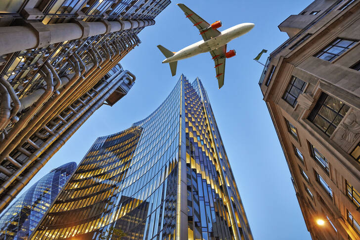 Plane over London skyscrapers