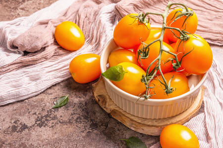 Oranje tomaten in een keramische kom