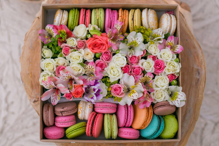 Macarons och blommor i en låda