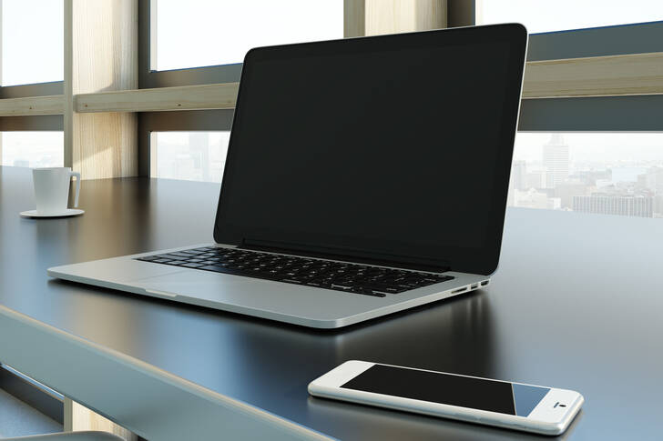 Bir dizüstü bilgisayar ve bir akıllı telefon bir masanın üzerinde