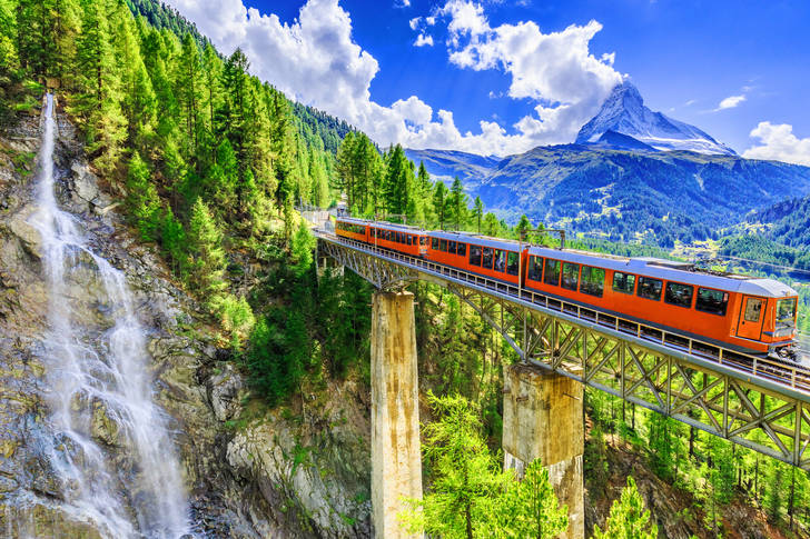 Panoramic train in the mountains with a waterfall