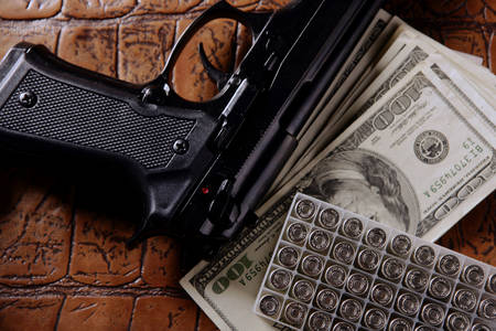 Dolarske novčanice, pištolj i kertridži