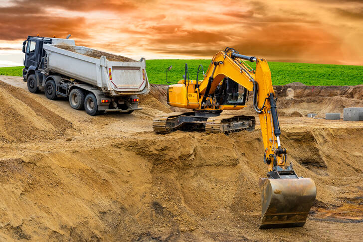 Excavator and dump truck at construction site