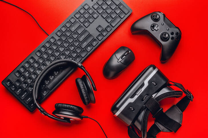 Keyboard, glasses, and headphones on a red background