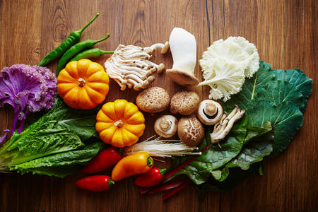 Vegetables and mushrooms on a wooden background