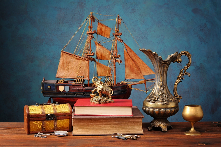 Velero, jarra y libros sobre la mesa.