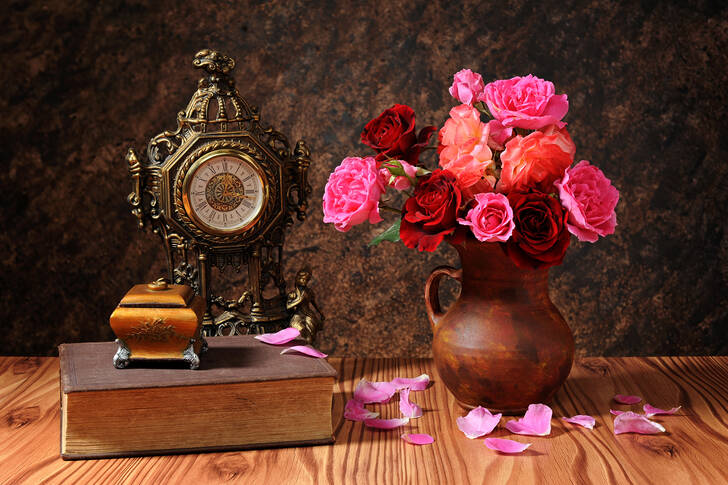 Rosor i en vas och en klocka