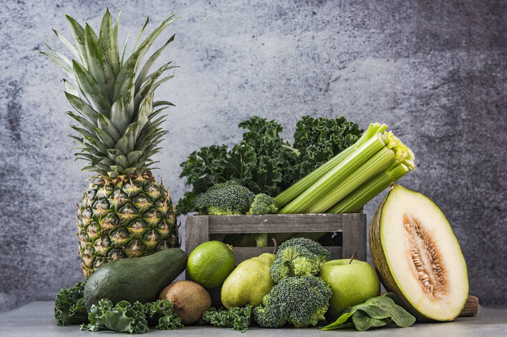 Frutas y verduras sobre un fondo gris.