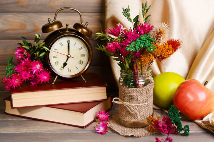 Clock on the table with flowers