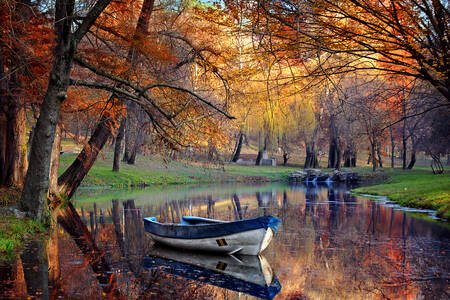 Barco en un lago en el bosque de otoño