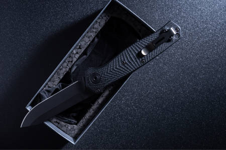 Folding knife on black background