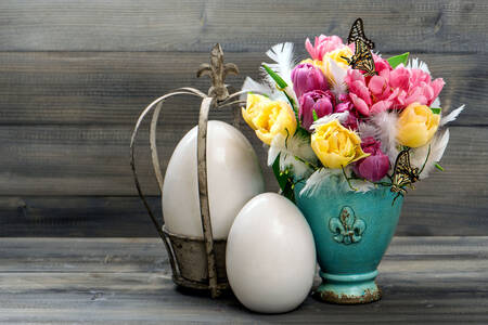 Tulipanes y huevos sobre la mesa.