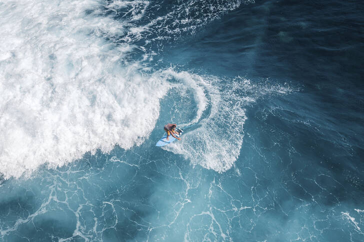 Surfař jedoucí na oceánské vlně