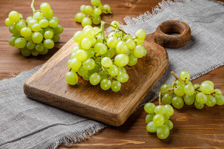 Uvas brancas sobre uma tábua de madeira