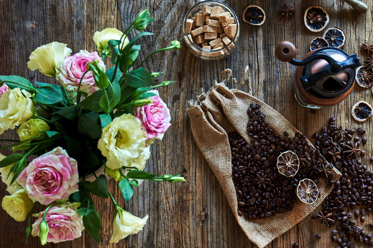 Coffee beans on a table with flowers