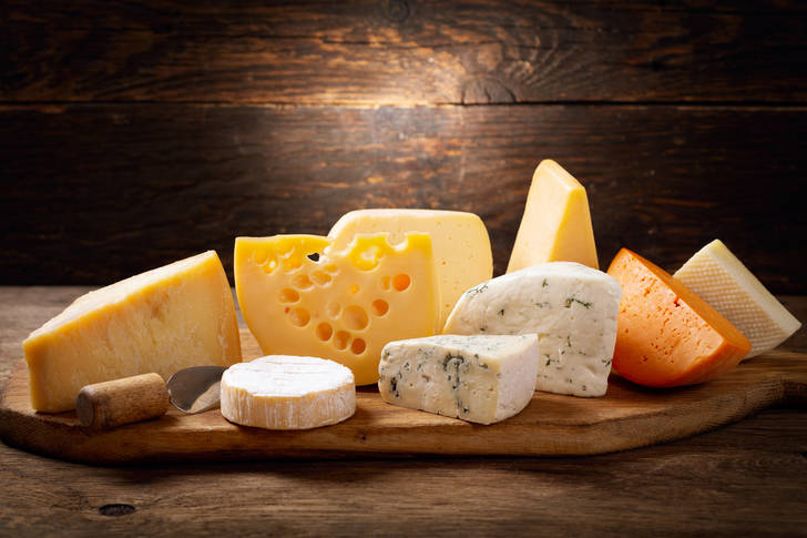 Different types of cheese on a wooden board