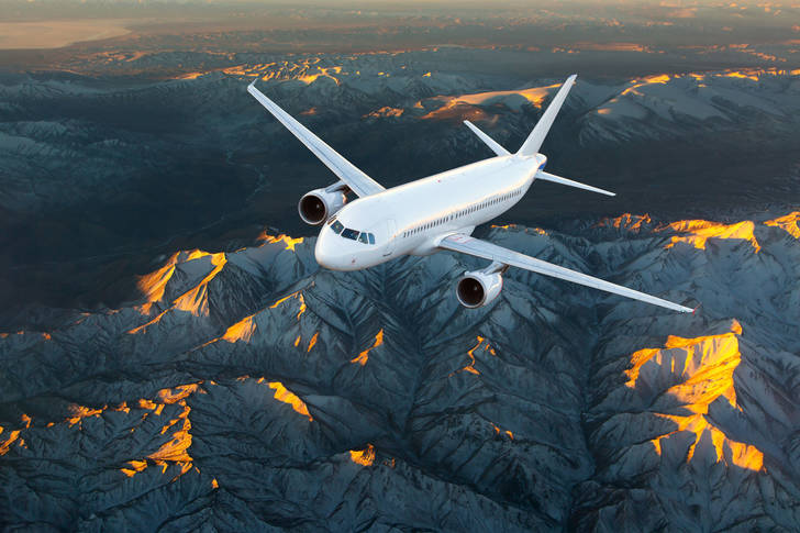 Airplane in flight over the mountains