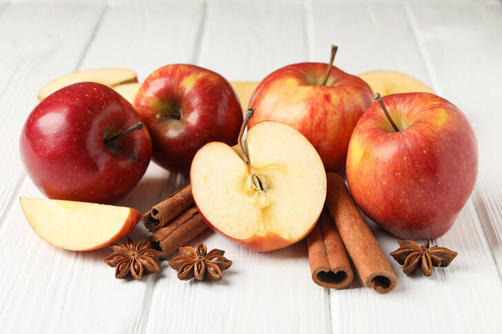 تفاح وقرفة على خلفية خشبية