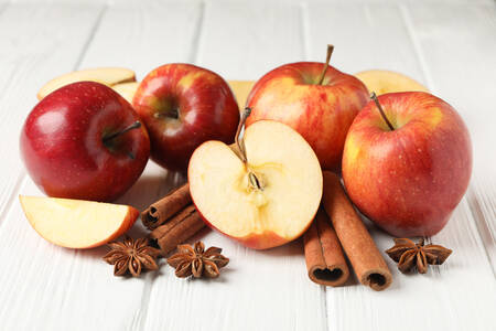 Μήλα και κανέλα σε ξύλινο φόντο