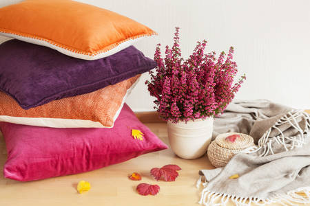 Färgglada kuddar och en blomkruka med lavendel