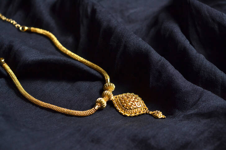 Gold necklace on black fabric