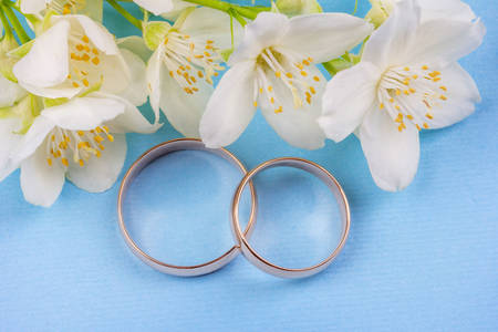 Сватбени пръстени и бели цветя