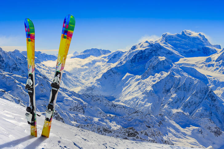 Skis against the backdrop of snow-capped mountains