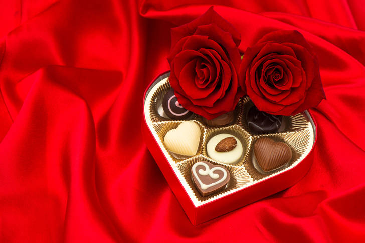 Roses and chocolates on red satin