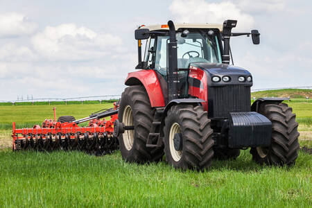 Červený traktor s lisem na seno