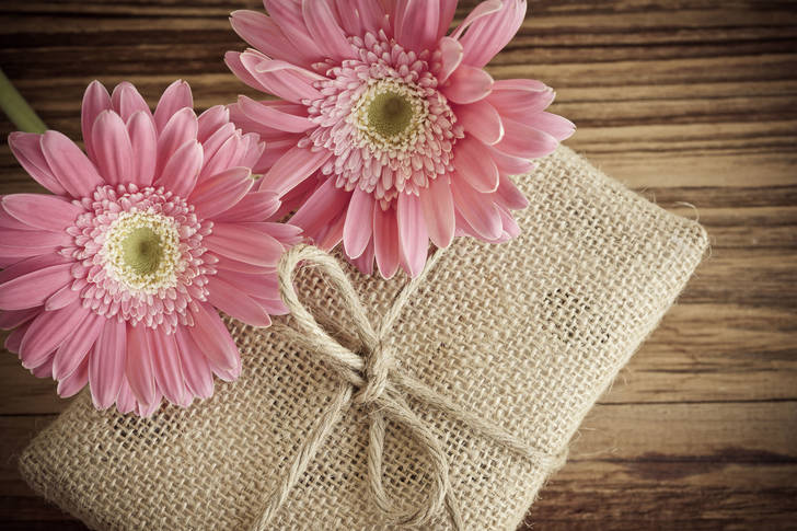 Gerberas and a gift on a wooden table