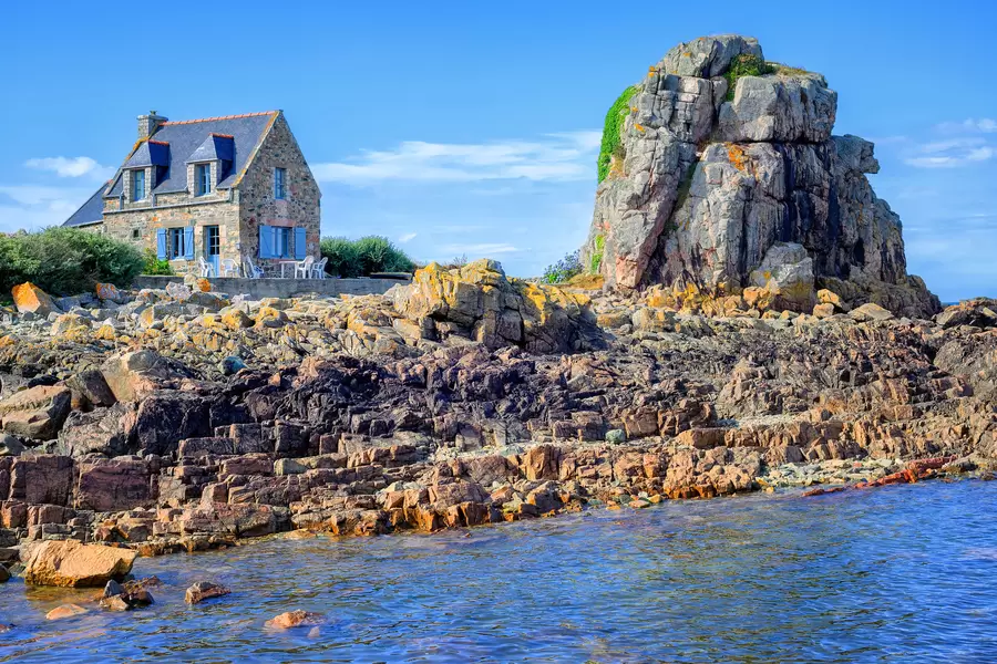 Stenen huis op een rotsachtige kust