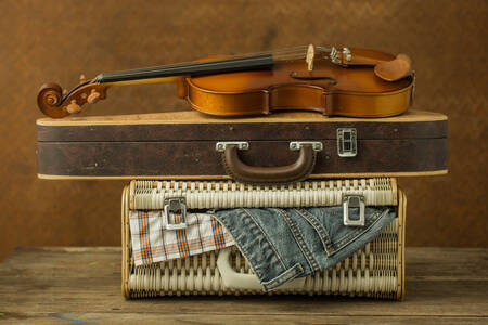 An old violin and a case on a suitcase