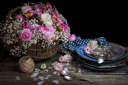 Kytice květin v koši na stole