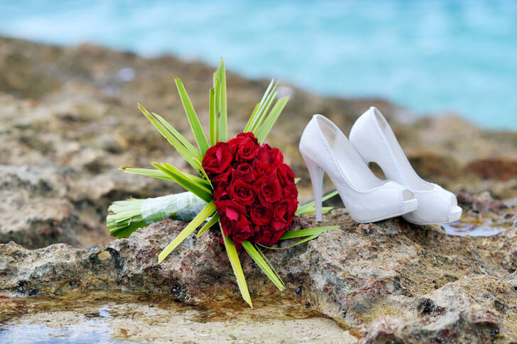 Wedding shoes and bouquet by the shore