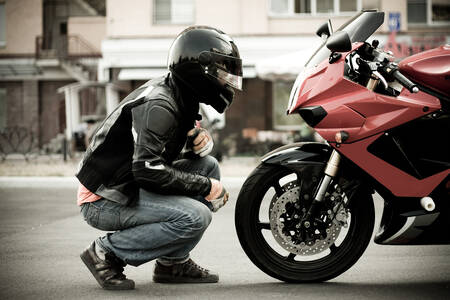 Motocyklista a červený motocykel