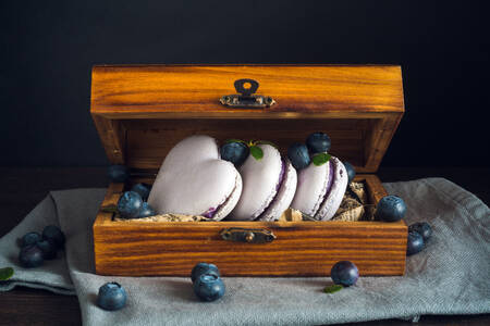 Macarons aux myrtilles dans une boîte en bois