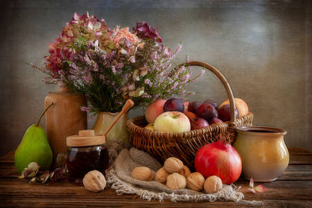 Flores, frutas y nueces sobre la mesa.