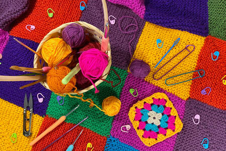Knitting supplies on a multi-colored blanket