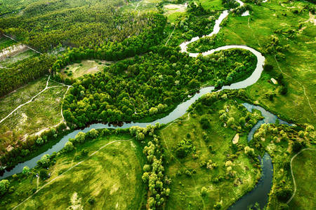 A winding river in a green field