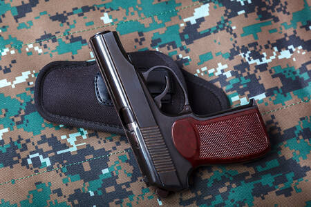 Pistol på en kamouflagebakgrund