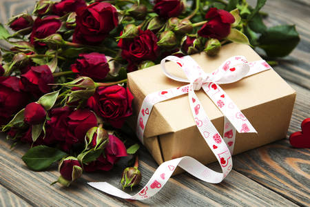 Buchet de trandafiri și un cadou pe masă