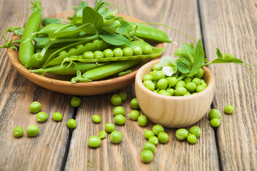 Petits pois dans un bol en bois